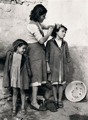 Mujer peinando a unas niñas